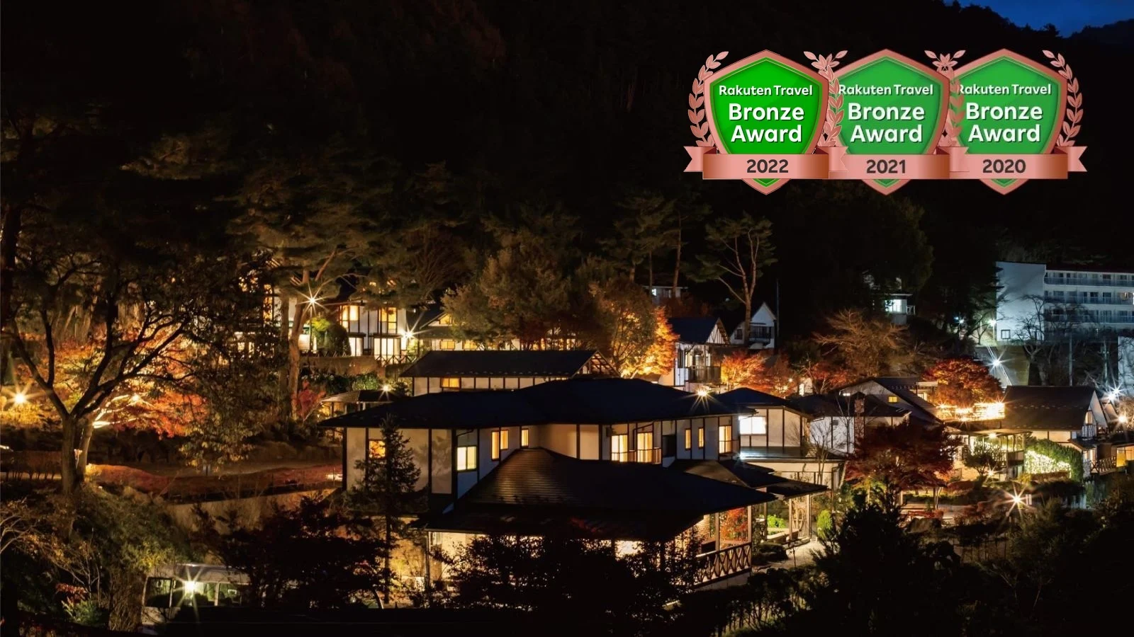 The grounds of Kawaguchiko Country Cottage Ban at night, with lit detached cottages scattered across the slope (photo supplied by Rakuten Travel)