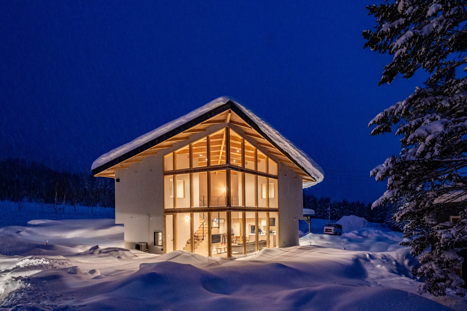 The exterior of a Rusutsu Hills Centro whole-house villa at night, surrounded by snow (photo: Rakuten Travel)