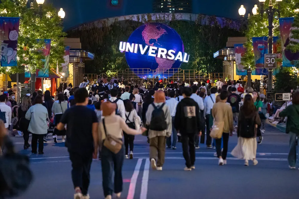 Evening crowds heading toward the Universal globe at the entrance of Universal Studios Japan